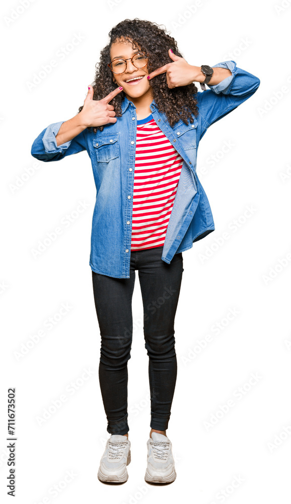 Young beautiful woman with curly hair wearing glasses smiling confident showing and pointing with fingers teeth and mouth. Health concept. Young beautiful woman with curly hair wearing glasses smiling confident showing and pointing with fingers teeth and mouth. Health concept.