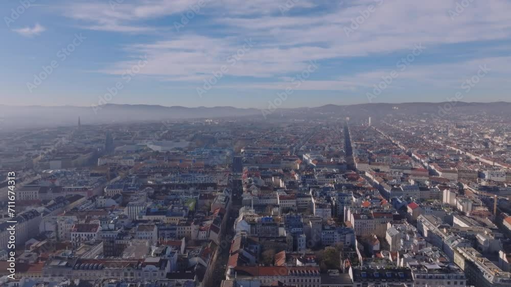 Fly above residential urban borough in large city on sunny day. Streets and buildings in metropolis, morning haze. Vienna, Austria Fly above residential urban borough in large city on sunny day. Streets and buildings in metropolis, morning haze. Vienna, Austria