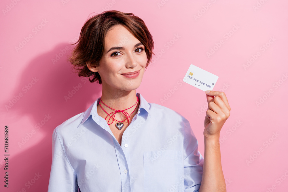 Portrait of gorgeous friendly lady hand hold demonstrate plastic debit card isolated on pink color background Portrait of gorgeous friendly lady hand hold demonstrate plastic debit card isolated on pink color background