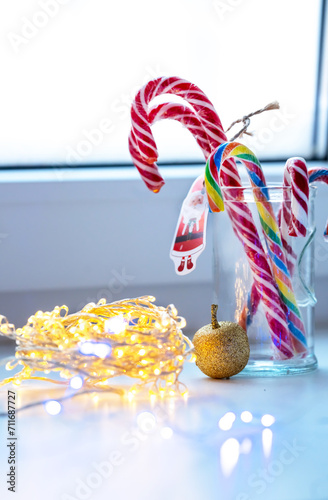 Christmas candies, a golden apple and a garland on the windowsill