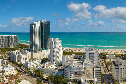 Tourism infrastructure in southern USA. South Beach sandy surface with tourists relaxing on hot Florida sun. Miami Beach city with high luxury hotels and condos © bilanol