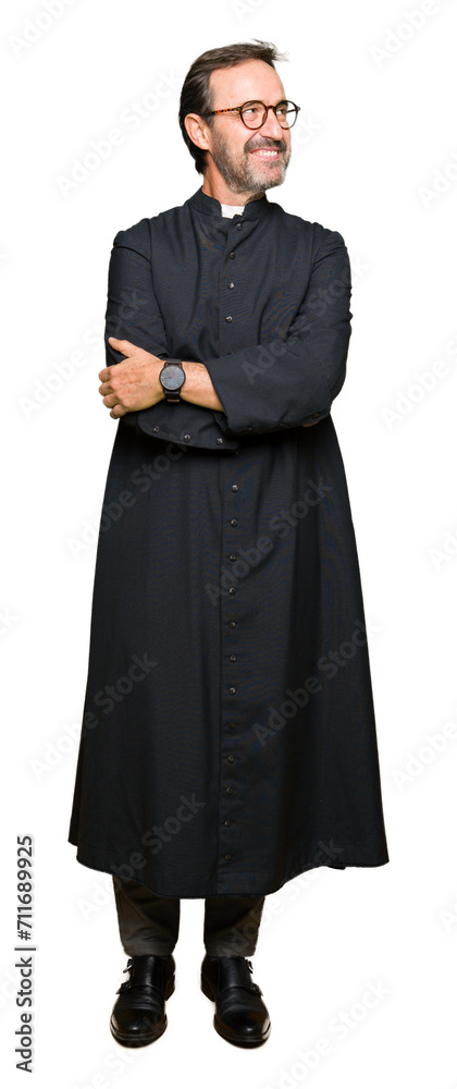 Middle age priest man wearing catholic robe smiling looking side and staring away thinking.