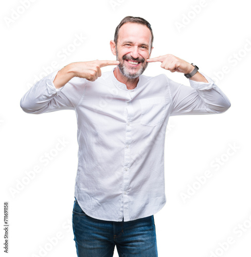 Middle age hoary senior man over isolated background smiling confident showing and pointing with fingers teeth and mouth. Health concept.