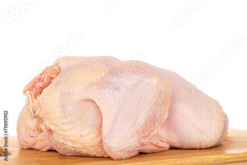 One raw chicken carcass on a bamboo kitchen board, macro, isolated on white background.