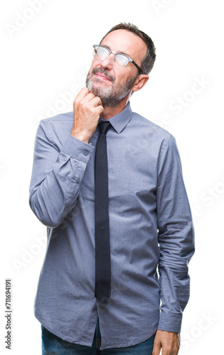 Middle age hoary senior business man wearing glasses over isolated background with hand on chin thinking about question, pensive expression. Smiling with thoughtful face. Doubt concept. © Krakenimages.com