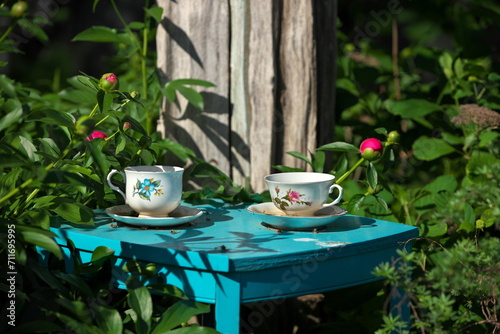 White China Teacups on Blue Table in Garden Double as Garden Art and Bird Baths
