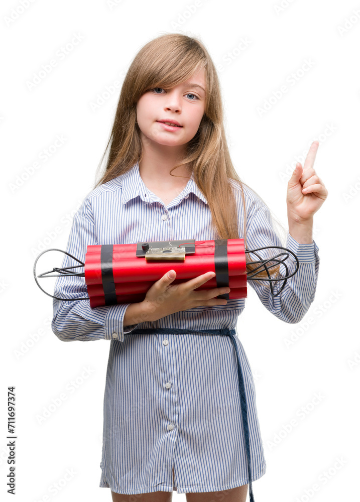 Young blonde child holding dynamite bomb very happy pointing with hand and finger to the side Young blonde child holding dynamite bomb very happy pointing with hand and finger to the side