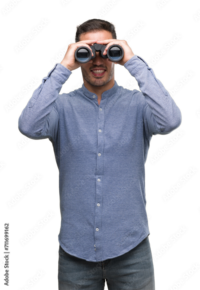 Handsome young man looking through binoculars with a happy face standing and smiling with a confident smile showing teeth Handsome young man looking through binoculars with a happy face standing and smiling with a confident smile showing teeth