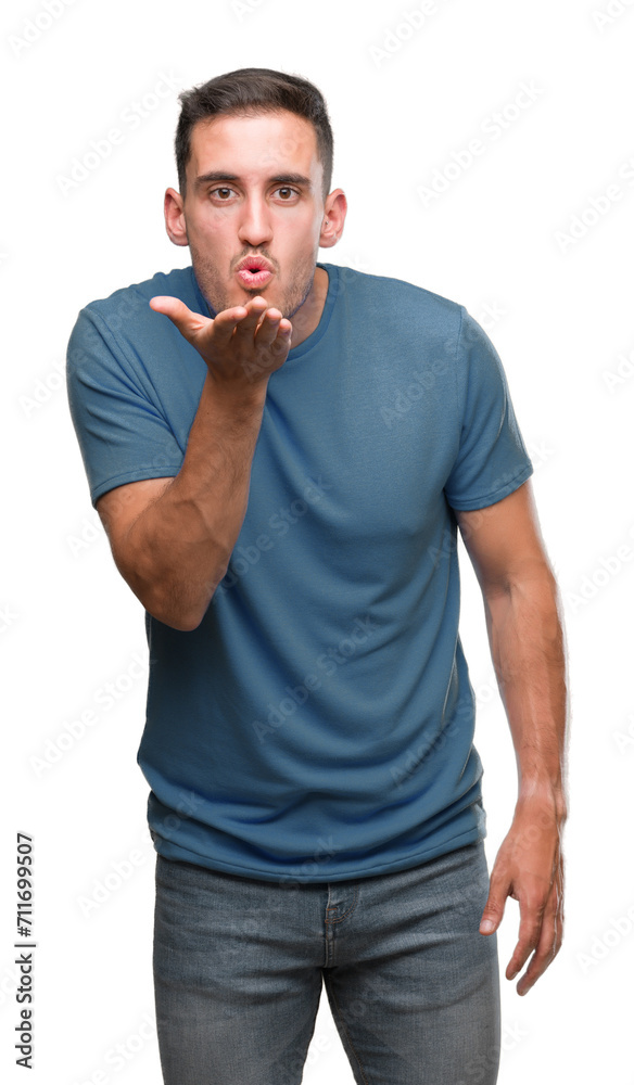 Handsome young casual man looking at the camera blowing a kiss with hand on air being lovely and sexy. Love expression. Handsome young casual man looking at the camera blowing a kiss with hand on air being lovely and sexy. Love expression.