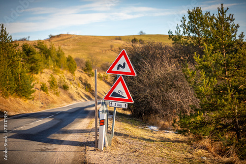 A road sign informing about a street with a significant slope and sharp turns