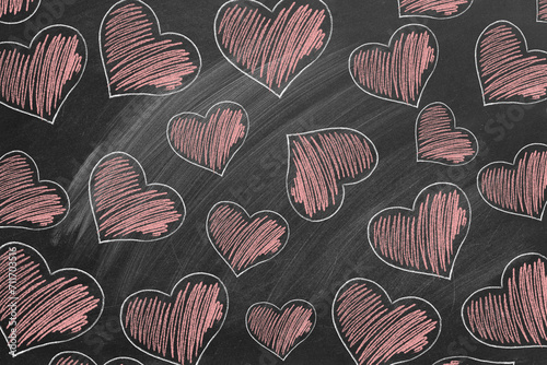 Many red hearts are drawn with chalk on the school chalkboard. Valentine's Day, love, compassion concept.