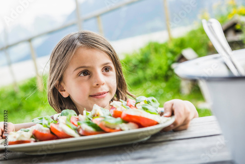 Portrait Mädchen mit Salat an einer Hütte, Österreich photo