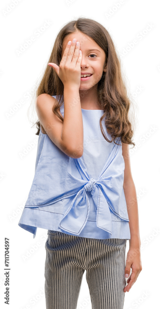 Brunette hispanic girl covering one eye with hand with confident smile on face and surprise emotion.