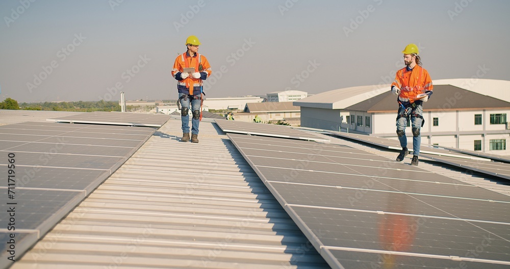 engineer man contractor worker architect construction manager in uniform and hardhat work to maintenance checking an operation and efficiency performance of photovoltaic solar panels on roof