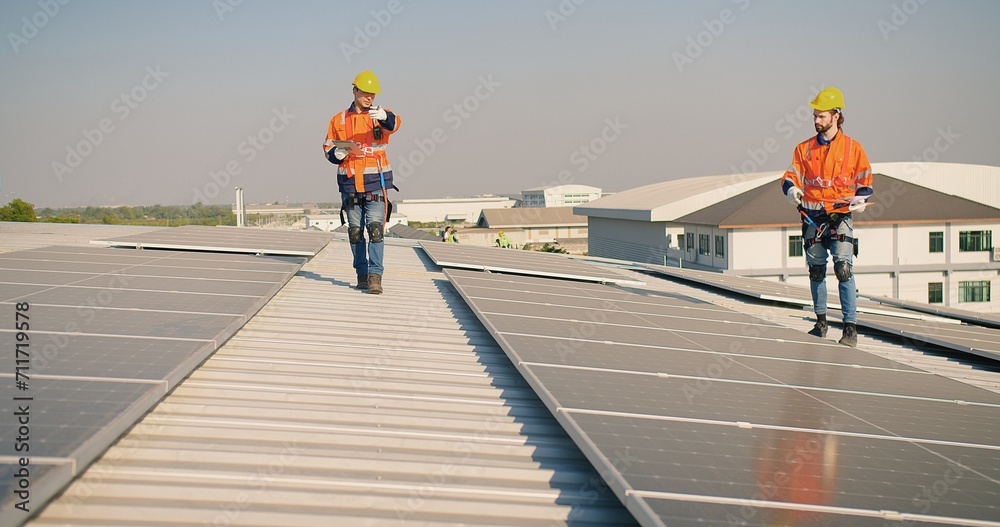 engineer man contractor worker architect construction manager in uniform and hardhat work to maintenance checking an operation and efficiency performance of photovoltaic solar panels on roof engineer man contractor worker architect construction manager in uniform and hardhat work to maintenance checking an operation and efficiency performance of photovoltaic solar panels on roof