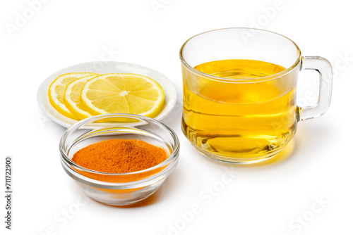 Glass with fresh made hot Curcuma drink and lemon isolated on white background