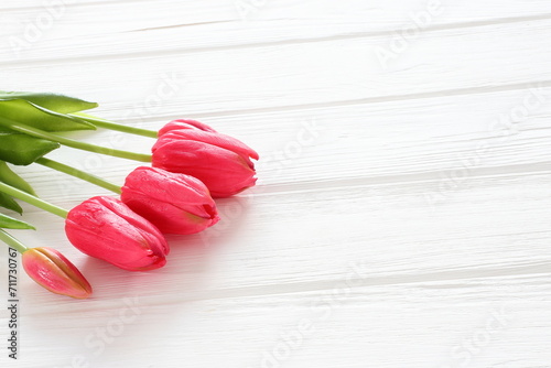 Red tulips on white wooden background, women´s day, mothers day, valentine, wedding, birthday, freeting card photo