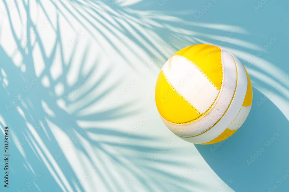 Beach Volleyball. Sport composition with White and yellow volleyball ball on light blue background with sunny light and shadows. Concept of healthy life, summer holiday, outdoor activities. Copy space