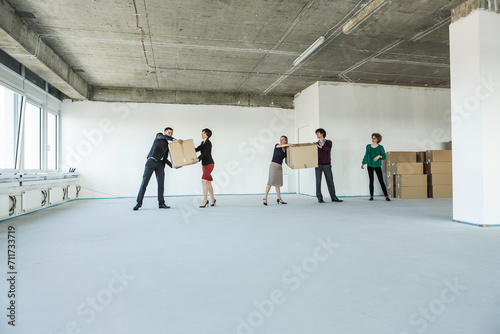 Colleagues of a startup helping each other move in, passing boxes to each other. Munich, Bavaria, Germany photo