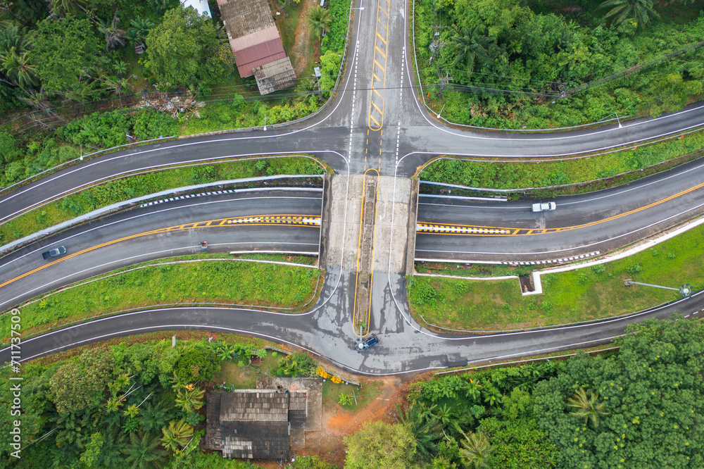 Aerial view of cars driving on highway or moterway. Overpass bridge street roads in connection network of architecture concept. Top view of forest trees. Nature landscape