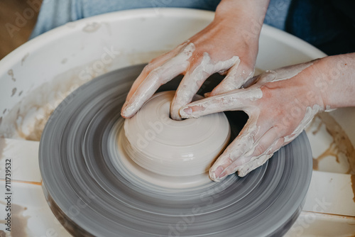 Beautiful female hands create a clay product on a pottery wheel. pottery, handmade Close-up
