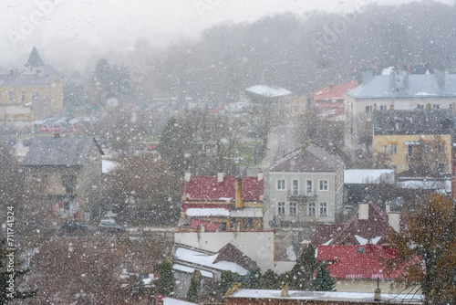 Obfite opady śniegu - duże mięsiste płatki śniegowe - nad miastem. Historyczne domy w mieście za zasłoną padającego śniegu .