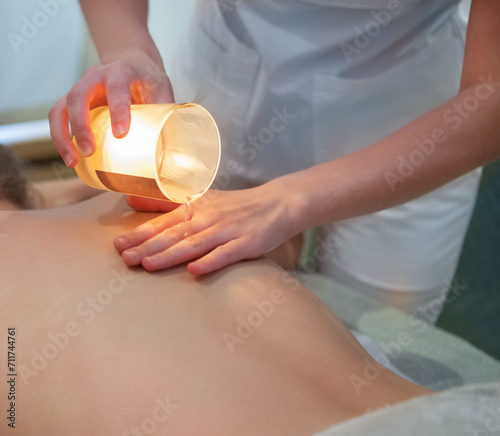Young woman getting spa massage with massage candle