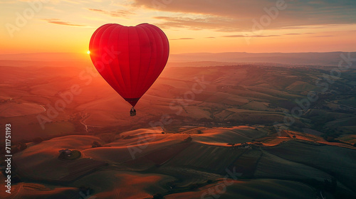Paisaje de colinas al amanecer con globo aerostático en forma de corazón photo