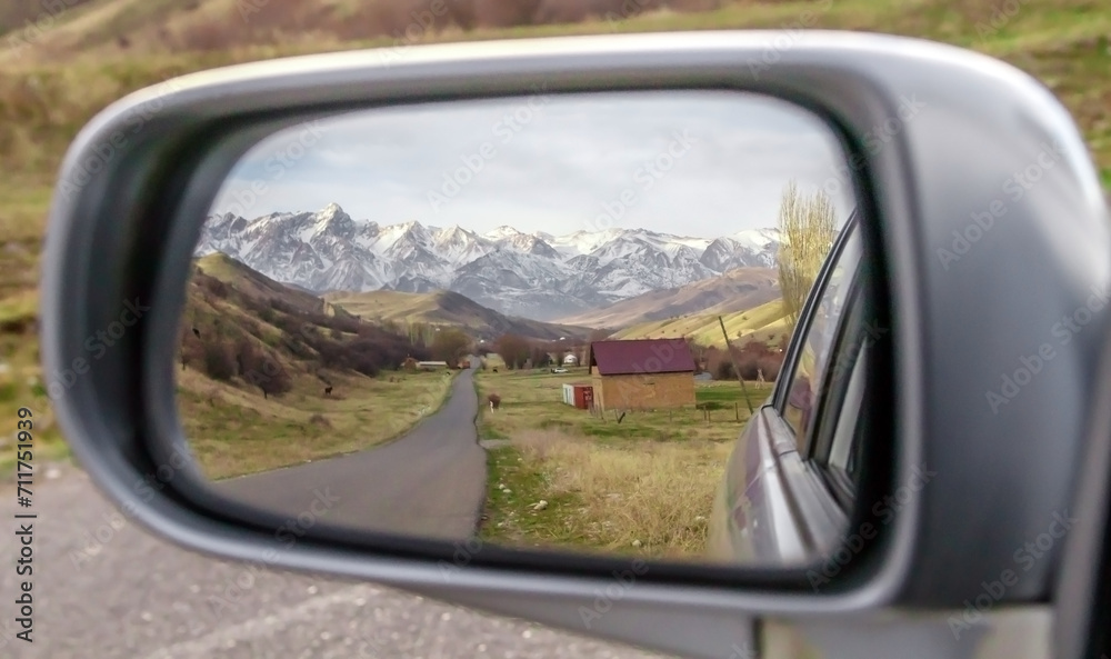 Reflection in the mirror of a car of beautiful snow-capped mountains and roads Reflection in the mirror of a car of beautiful snow-capped mountains and roads
