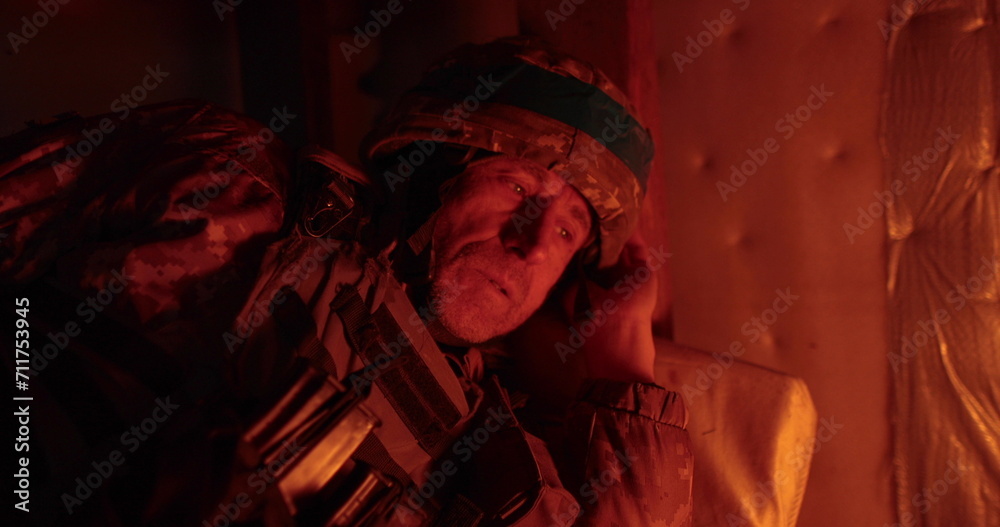 A soldier rests lying in a dugout in the glare of a burning trench candle. Ukrainian soldier in the dugout.