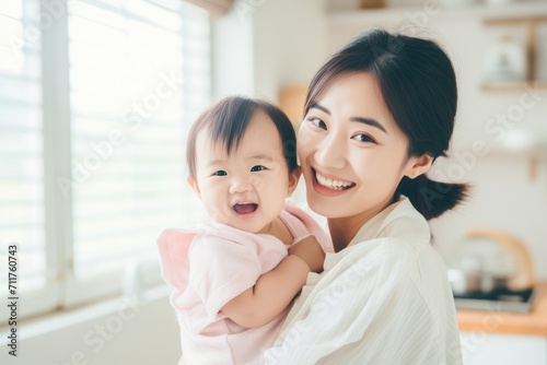 A heartwarming image of a woman holding a baby in her arms, exemplifying the powerful bond between mother and child, happy smiling young asian mother with little baby at home, AI Generated