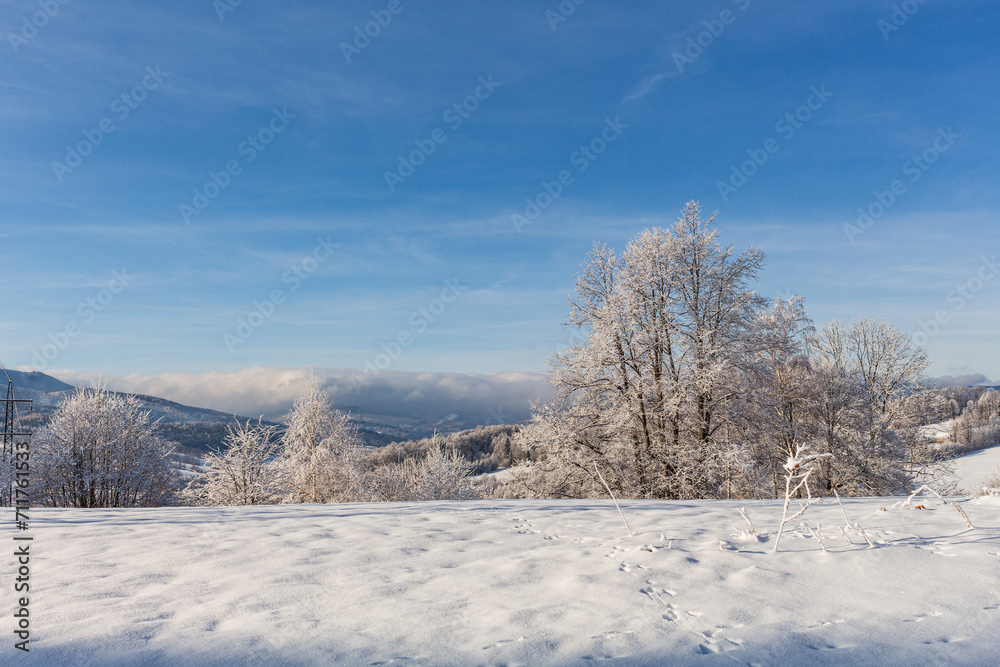 Fantastic winter landscape with wooden house in snowy mountains. Hight mountain peaks in foggy sunset sky. Christmas and winter vacations holiday concept Fantastic winter landscape with wooden house in snowy mountains. Hight mountain peaks in foggy sunset sky. Christmas and winter vacations holiday concept
