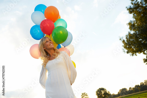 happy young woman with lots of balloons 