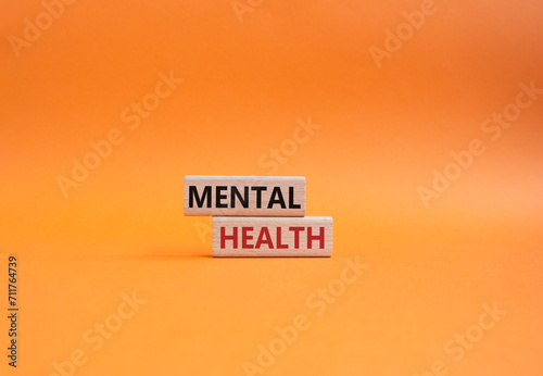 Mental Health symbol. Concept word Mental Health on wooden blocks. Beautiful orange background. Psychology and Mental Health concept. Copy space
