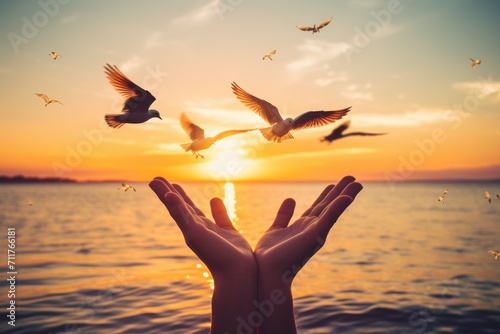 A person stands with outstretched arms, inviting birds as they soar gracefully over the glistening water, Hands open palm up worship with birds flying over calm water sunset background, AI Generated