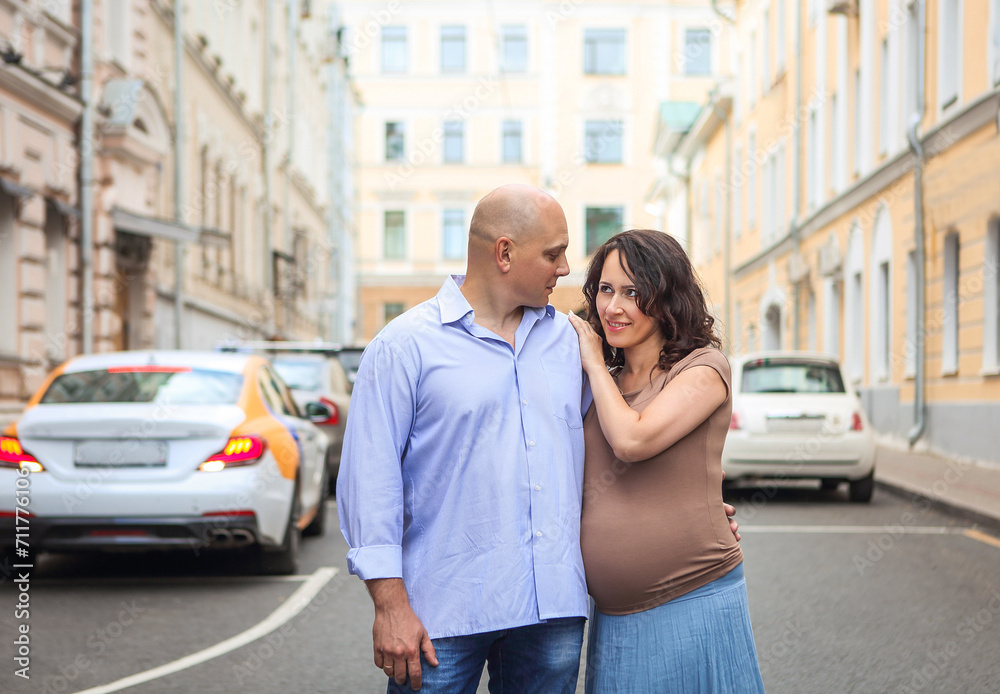 Loving pregnant couple on city street Loving pregnant couple on city street