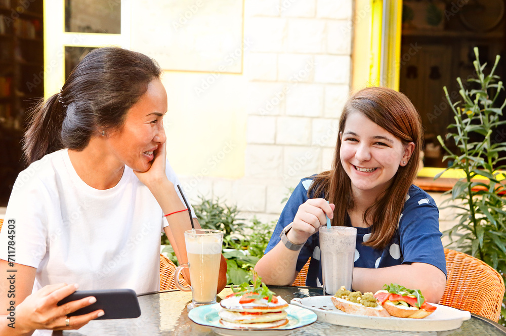 Cheerful multiethnic women enjoying lunch in outdoor cafe Cheerful multiethnic women enjoying lunch in outdoor cafe