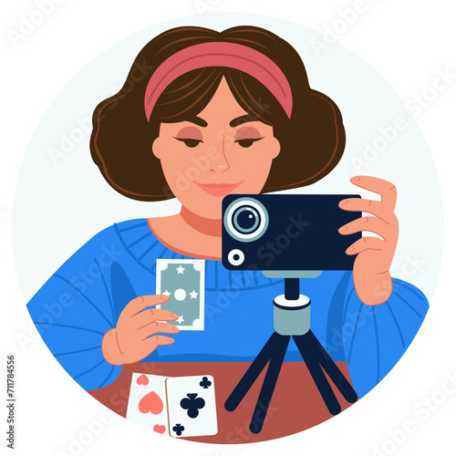 Witch, psychic, astrologer live fortune-telling on Tarot cards. A woman shoots a video blog on the phone. Close-up. Round background.  The concept of learning, prediction, entertainment, meditation. 