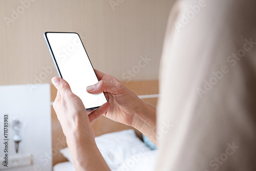 closeup of female hands using smartphone, white blank screen for mockup