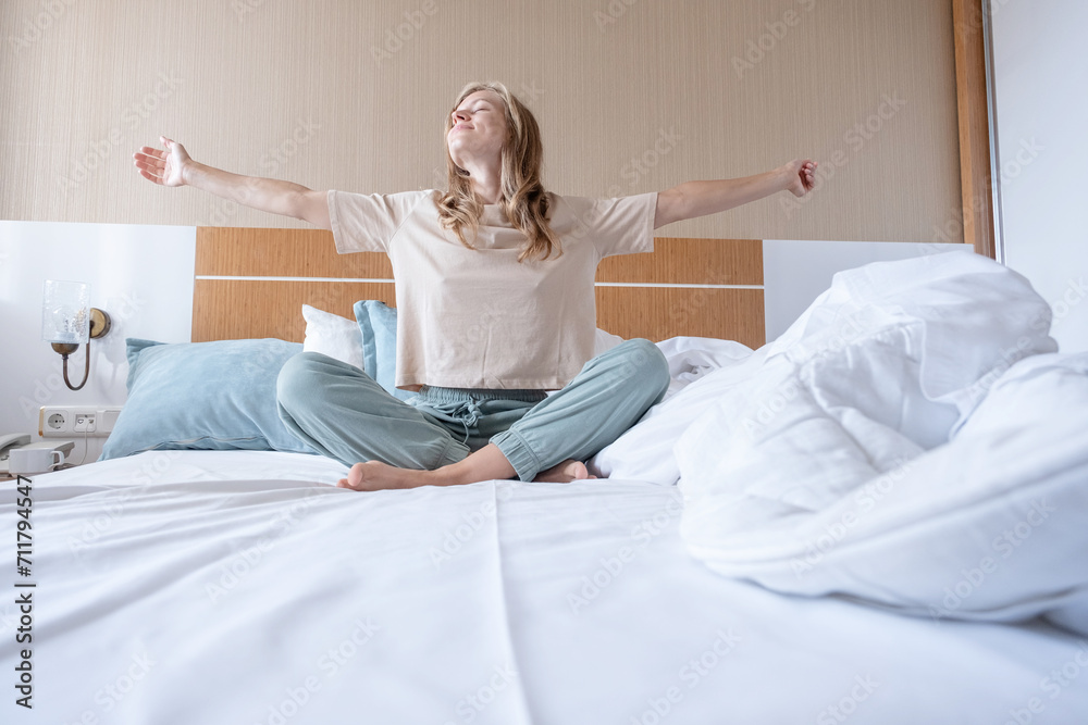 Woman stretching in bed after wake up Woman stretching in bed after wake up