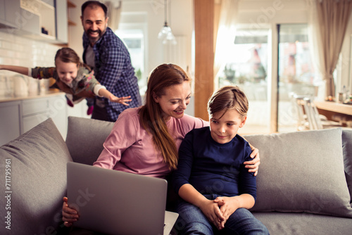 Happy family with two kids enjoying time together on the sofa at home