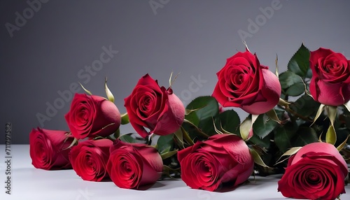 Red roses bouquet on white table and grey wall background 