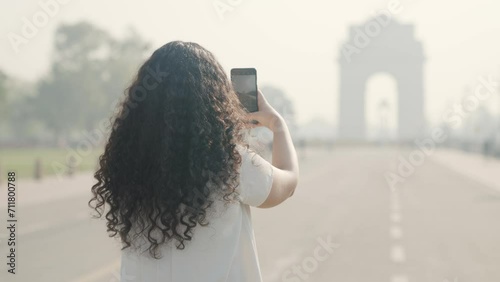 Indian Girl with Curly Hair Clicking Pictures of India Gate photo