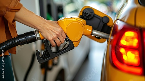 Woman's hand filling up at a gas station pump in a high-resolution image.