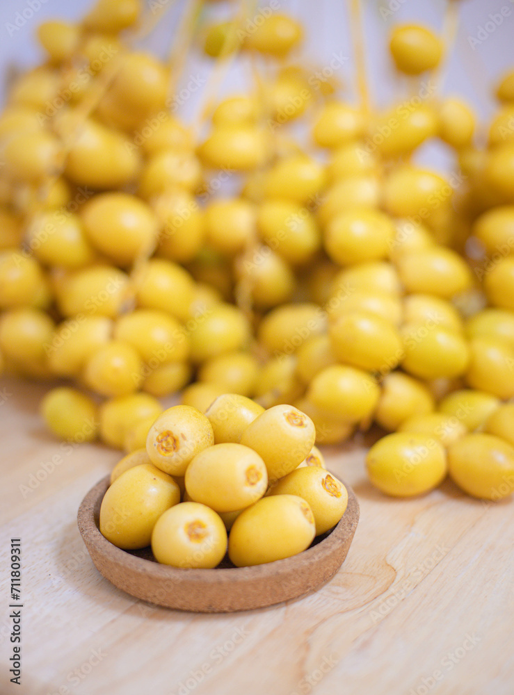Close up and selective focus fresh dates fruits in wooden bowl. Close up and selective focus fresh dates fruits in wooden bowl.