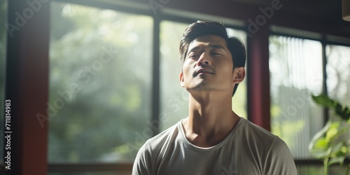 Asian man inhales deeply during meditation photo