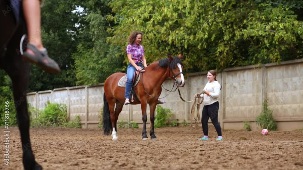 Woman does exercise leaning back, sitting in saddle on horse Woman does exercise leaning back, sitting in saddle on horse