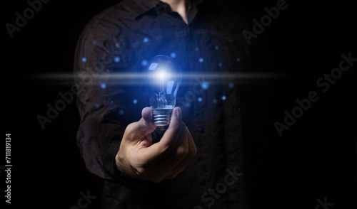 Man holding a light bulb in his hand, idea of creativity and inspiration concept of sustainable business development. Successful innovation ideas and inspiration ideas.	