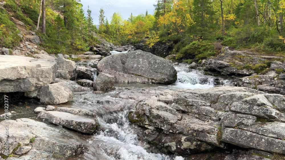 A beautiful waterfall in the autumn mountains beyond the Arctic Circle in the north, in Khibiny, Murmansk region. Panoramic view of a beautiful waterfall in the mountains in autumn, Kola Peninsula 4К