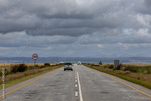 Converging lines of a well used road with rain clouds gathering